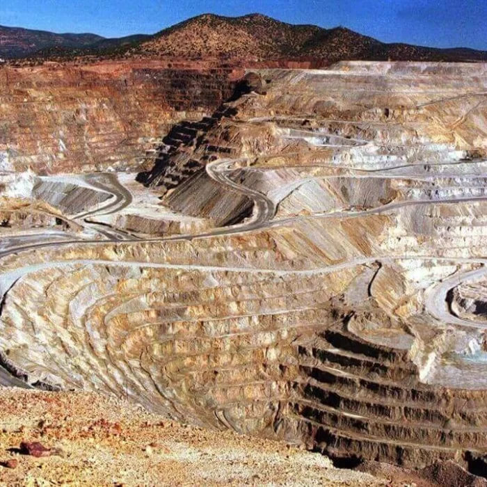 Sol tarafta üzerinde "BORSA İSTANBUL" yazısı ve logosu bulunan mavi tonlu dijital bir ekran, sağ tarafta ise teraslar halinde kazılmış büyük bir açık ocak maden sahasının genel görünümü yer alıyor.